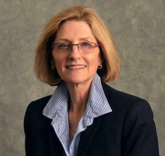 image of Holly Mayer, wearing glasses, in a blue shirt and black blazer