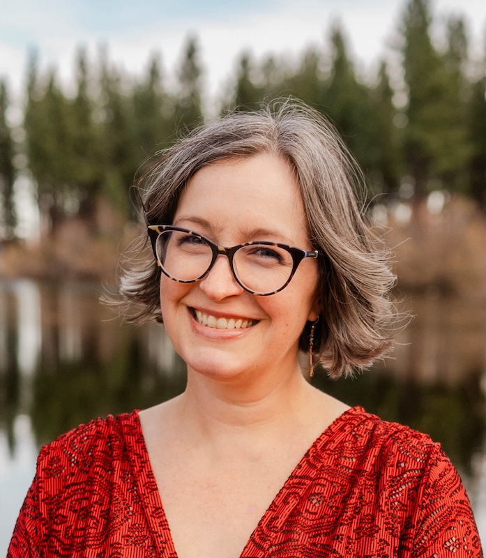 image of Renata wearing glasses and a red blouse smiling at the camera