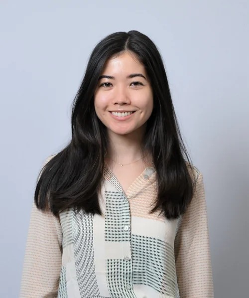 image of Melody with long black hair wearing light pattern blouse smiling at the camera