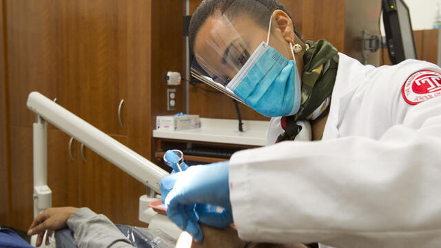 Temple Dentist work in clinic with blue gloves