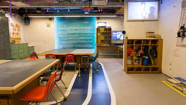 Tables and chair arranged to look like a classroom in the reForm exhibit.
