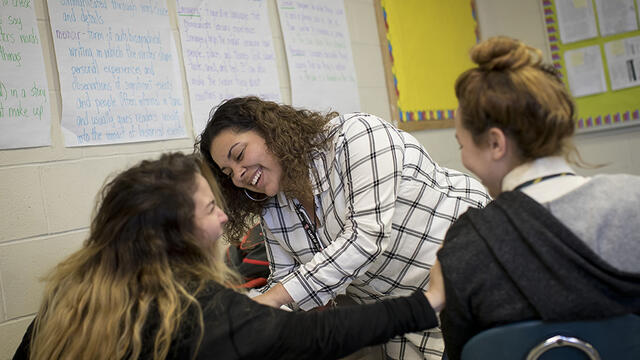 A female Temple student interacting with high school students in a classroom.