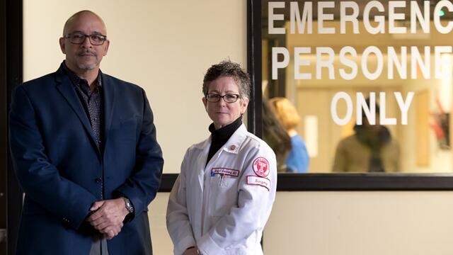 Surgeon Amy Goldberg and outreach coordinator Scott Charles standing by ER doors