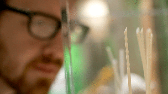 A man looking at 3D printed surgical needles