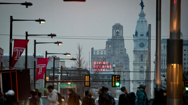 People crossing Broad Street on Temple s campus with City Hall in the background