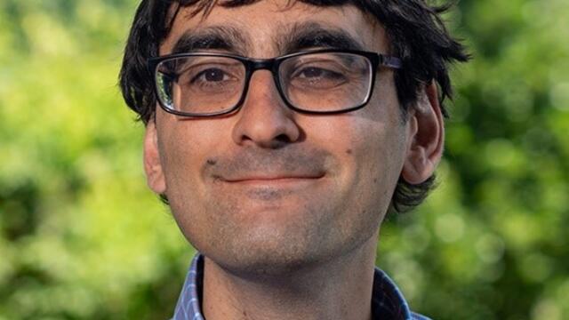 image of Enghin Atalay wearing glasses in a blue button down shirt