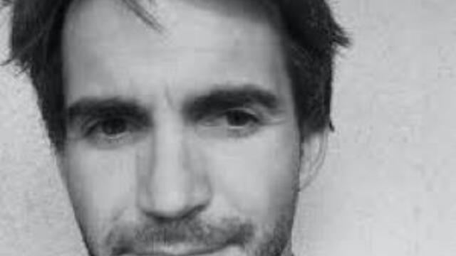 image of DW in black and white half smiling at the camera
