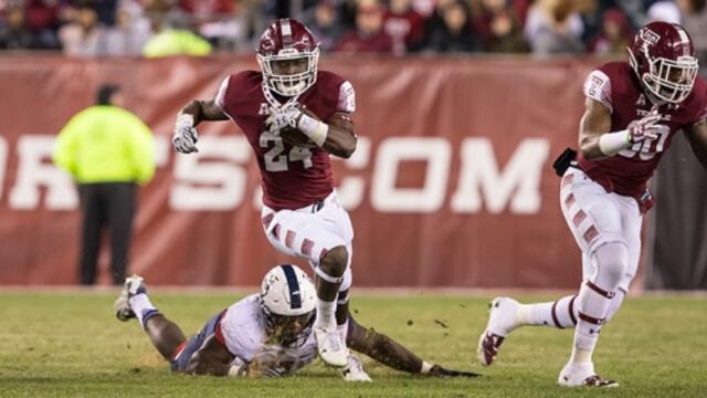 A Temple football player dodging a tackle in the game against UConn.