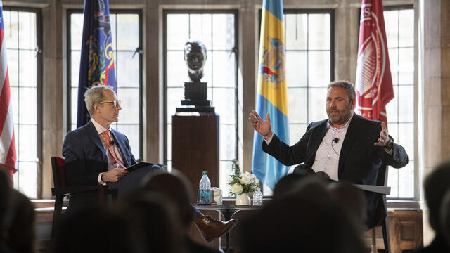 Richard Deeg and Christopher Barnett seated in conversation in front of an audience in Mitten Hall