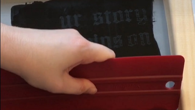Hand using screenprinting tools.