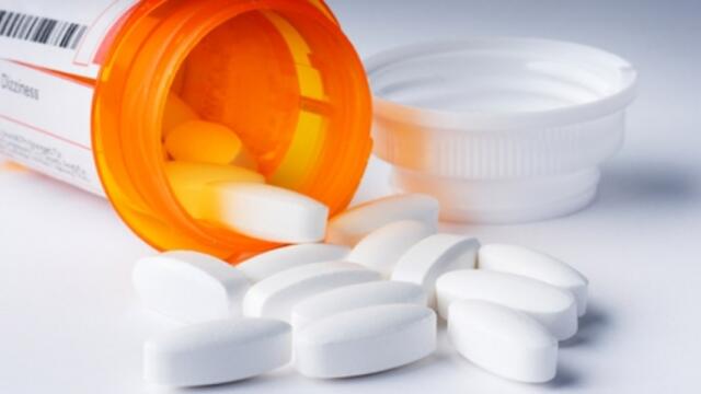 Prescription pills spilling out of a prescription bottle.