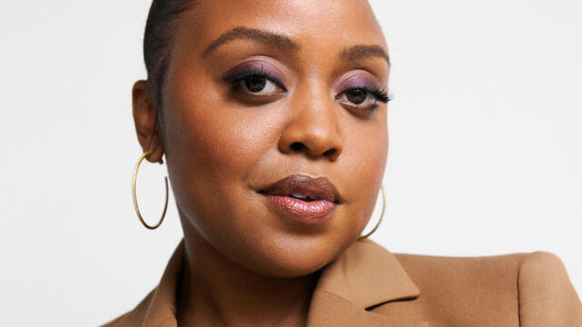 a close up of Quinta Brunson in a tan suit