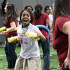 A student practicing her fencing technique with a yellow pool noodle.