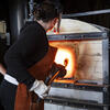 Temple faculty demonstrating glassblowing furnace
