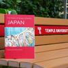 A copy of The History of Temple University Japan on a bench