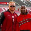 Two men standing on the sideline of a Temple football game.