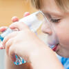 a toddler drinking a glass of water