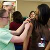 A member of the Flu Crew applying a bandage to an employee after a vaccination.