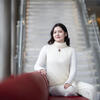 Image of Ayna Mammedova sitting on red couch. 