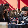 Two students laughing and playing games at a table during the celebration